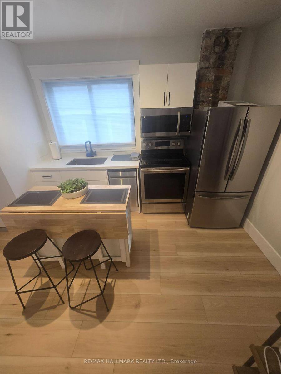 A kitchen with a table and chairs in front of a refrigerator.