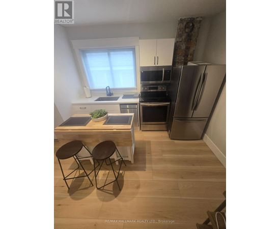 A kitchen with a table and chairs in front of a refrigerator.