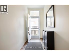 A hallway with a door leading to a balcony.