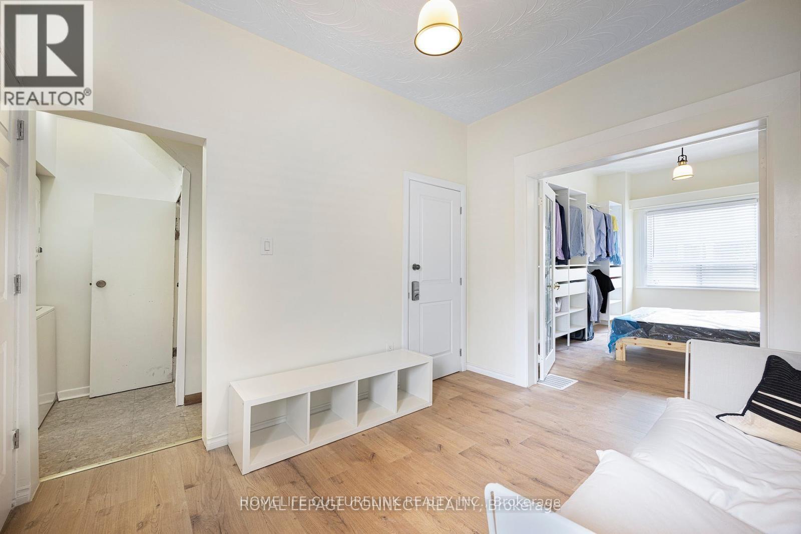 A bedroom with a bed, a bench, and a window.