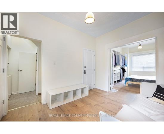 A bedroom with a bed, a bench, and a window.
