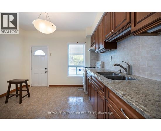 A kitchen with brown cabinets and a sink.