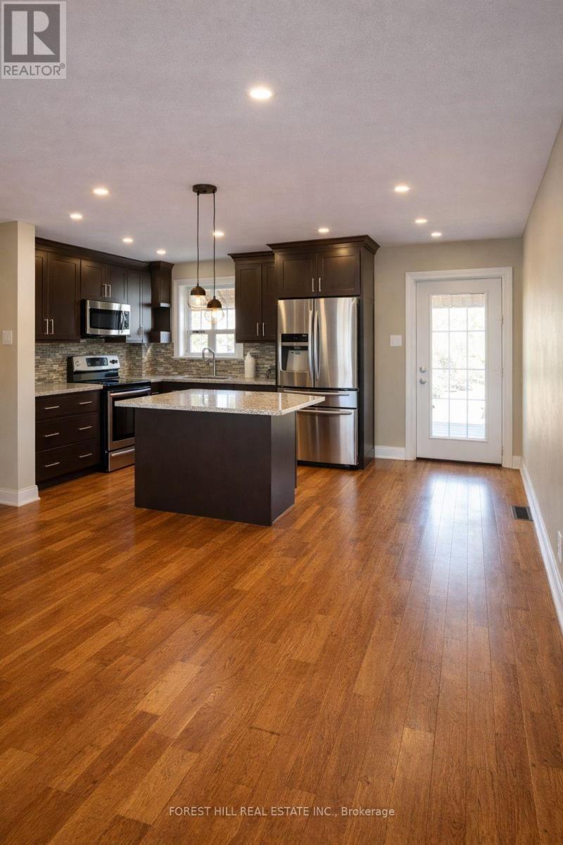 A modern kitchen with wooden floors and a large island.
