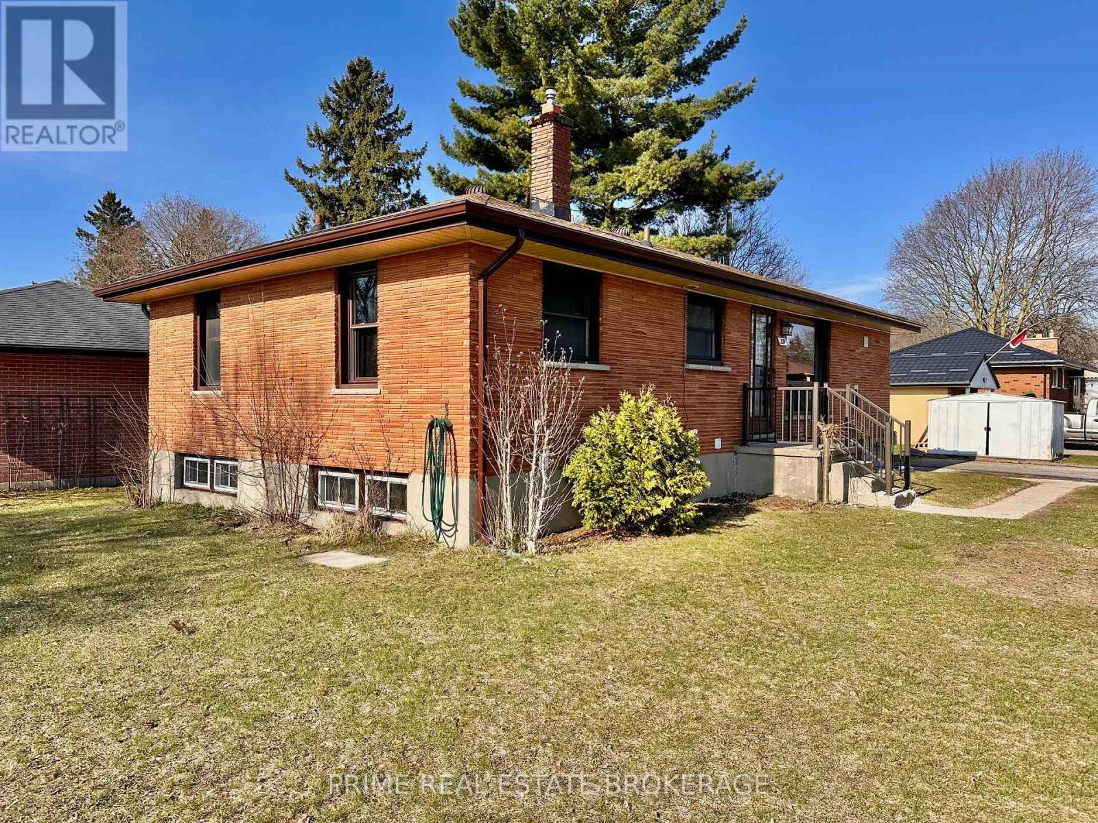 A brick house with a tree in front of it.