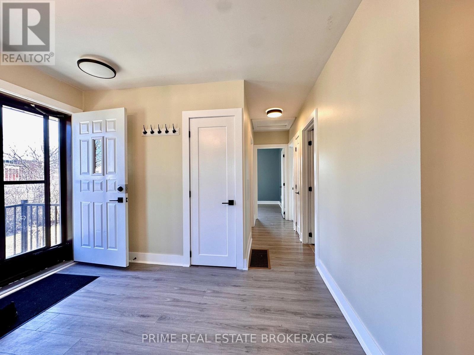 A hallway with white doors and a blue door at the end.