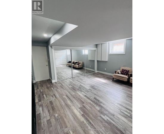 A living room with a couch and a slanted ceiling.