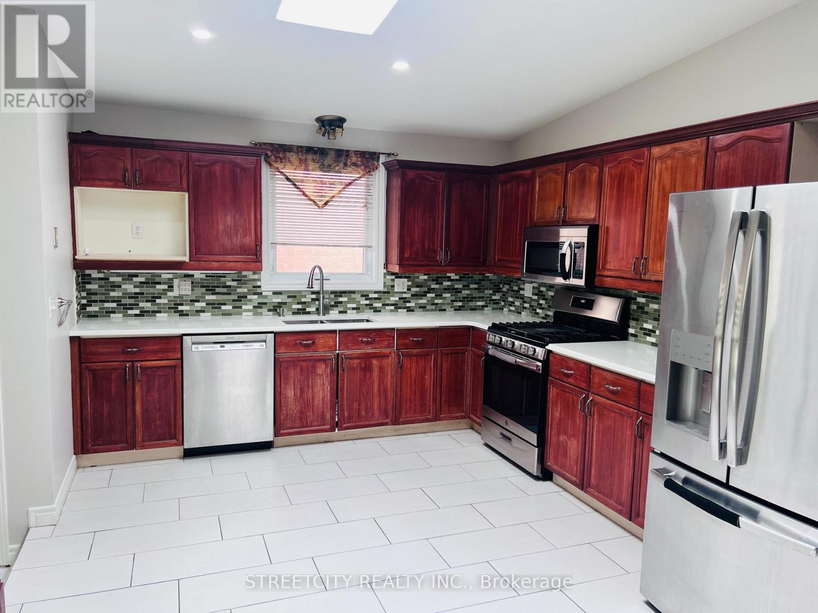 A kitchen with red cabinets and white appliances.