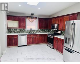 A kitchen with red cabinets and white appliances.