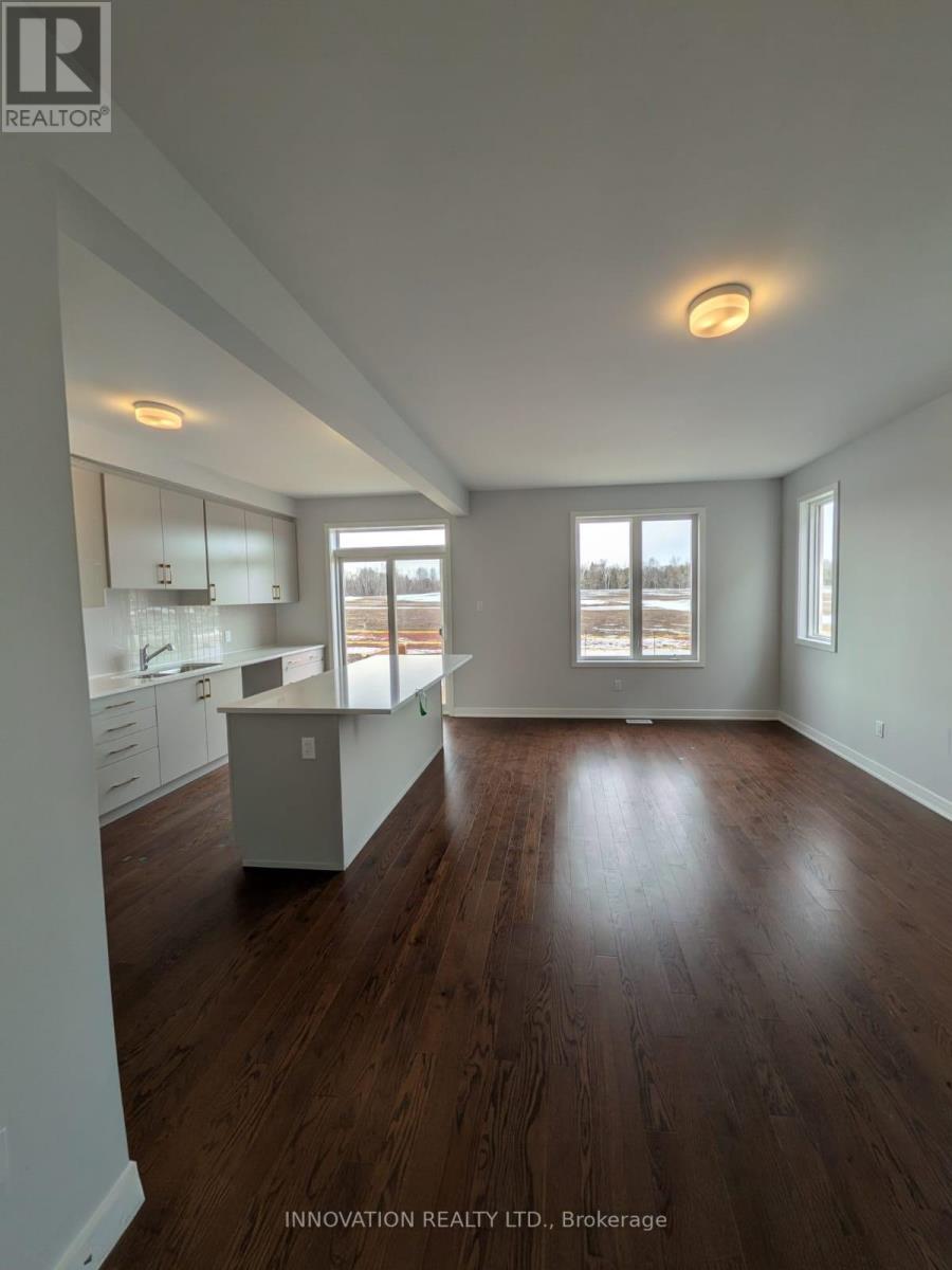 A spacious room with wooden floors and white walls.