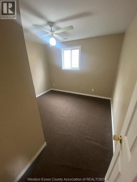 A room with a ceiling fan and a window.