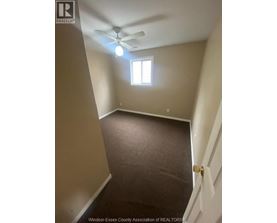 A room with a ceiling fan and a window.