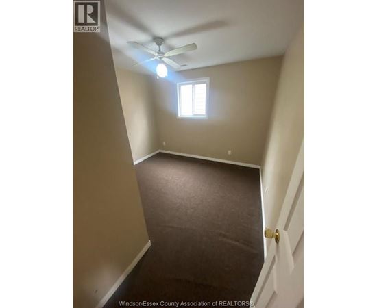 A room with a ceiling fan and a window.