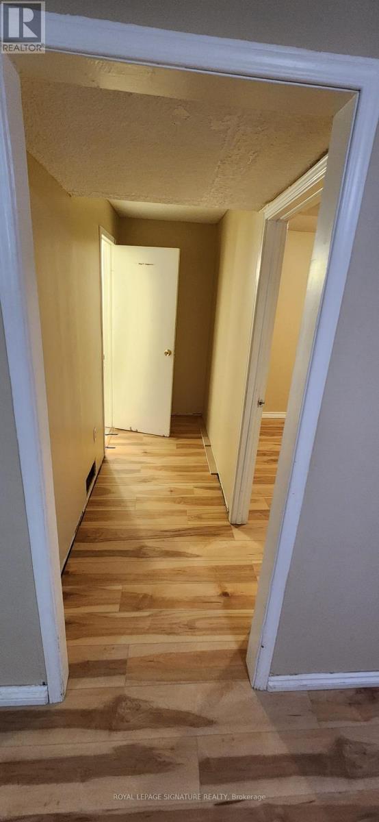 A hallway with wooden floors and white walls.