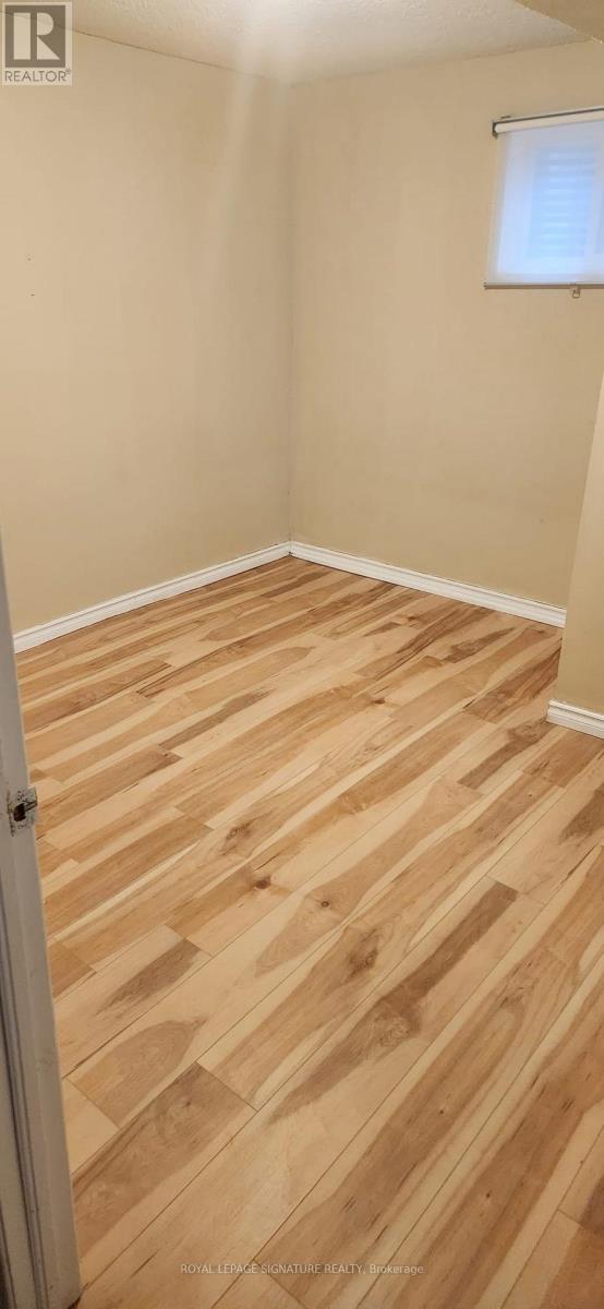 A room with wooden flooring and a window.