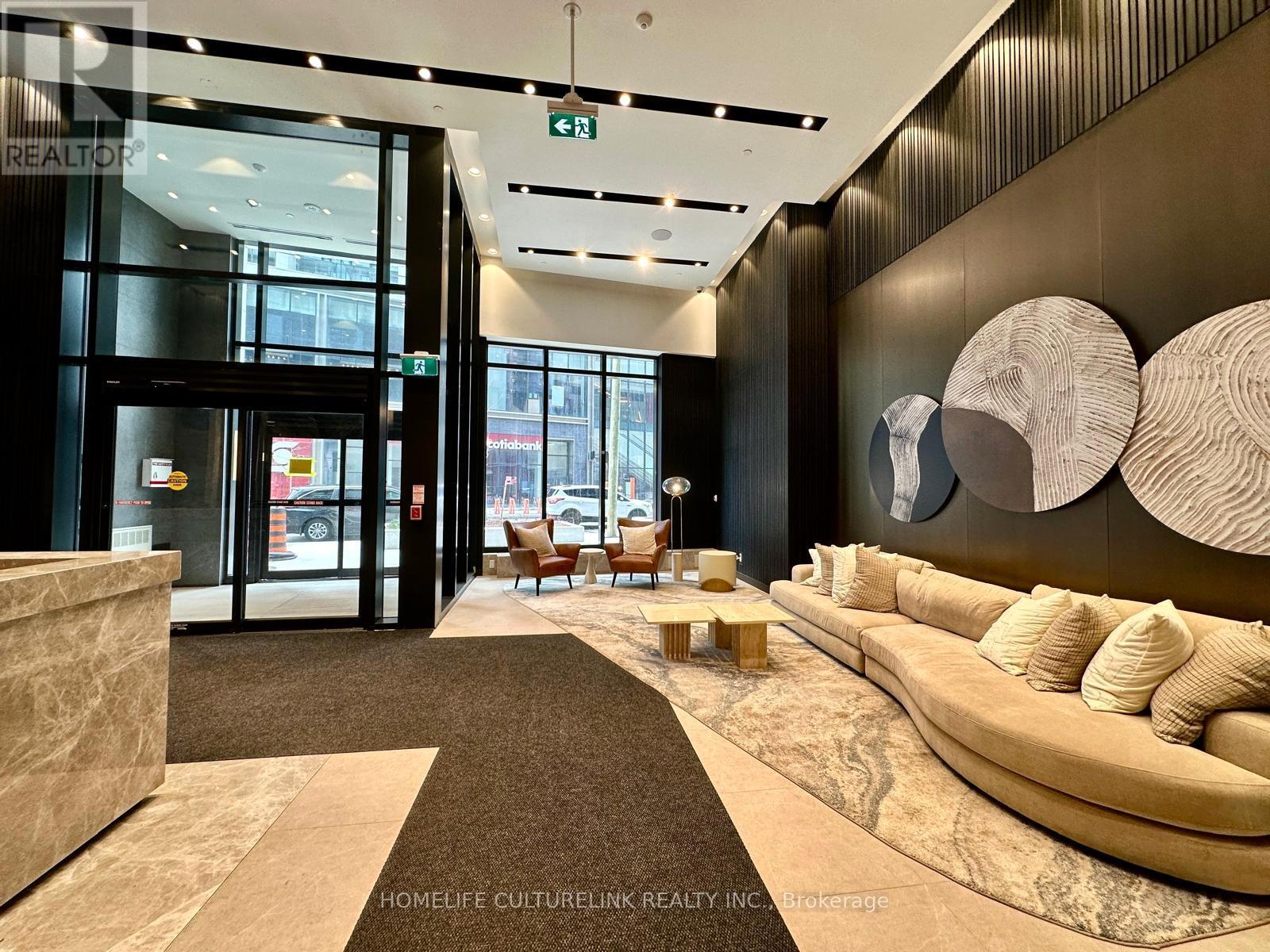 A modern office lobby with a reception desk and a large couch.