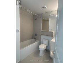 A white toilet in a small bathroom with a glass shower stall.