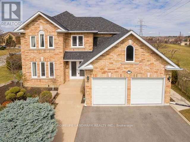 A two-story brick house with a garage and a driveway.
