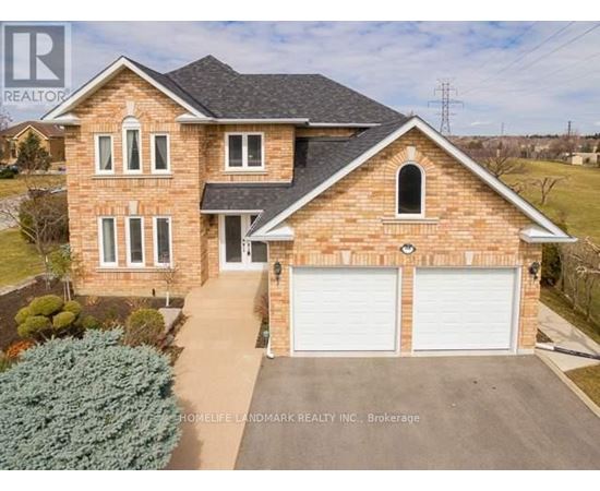 A two-story brick house with a garage and a driveway.