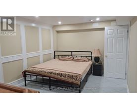 A bedroom with a bed, nightstand, and lamp.