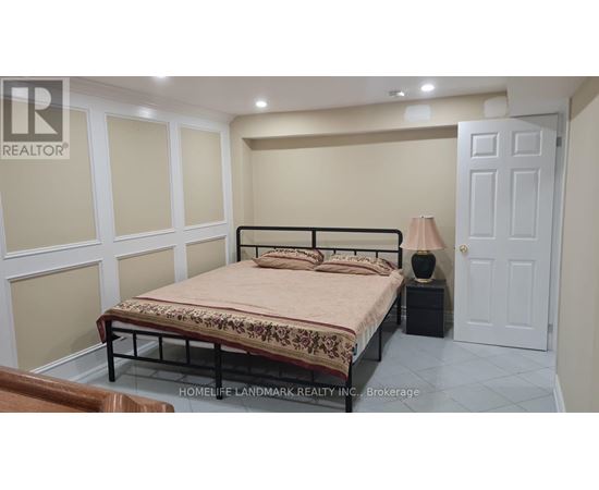 A bedroom with a bed, nightstand, and lamp.