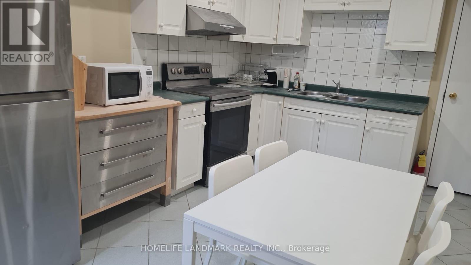 A kitchen with a white table and white cabinets.