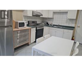A kitchen with a white table and white cabinets.