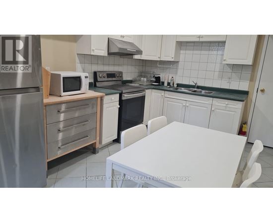 A kitchen with a white table and white cabinets.