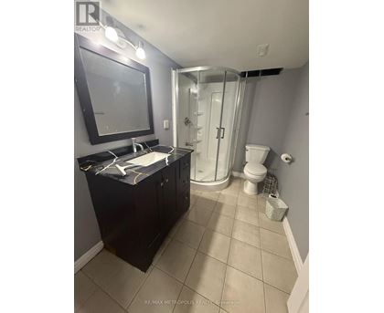 A bathroom with a black cabinet and a white sink.