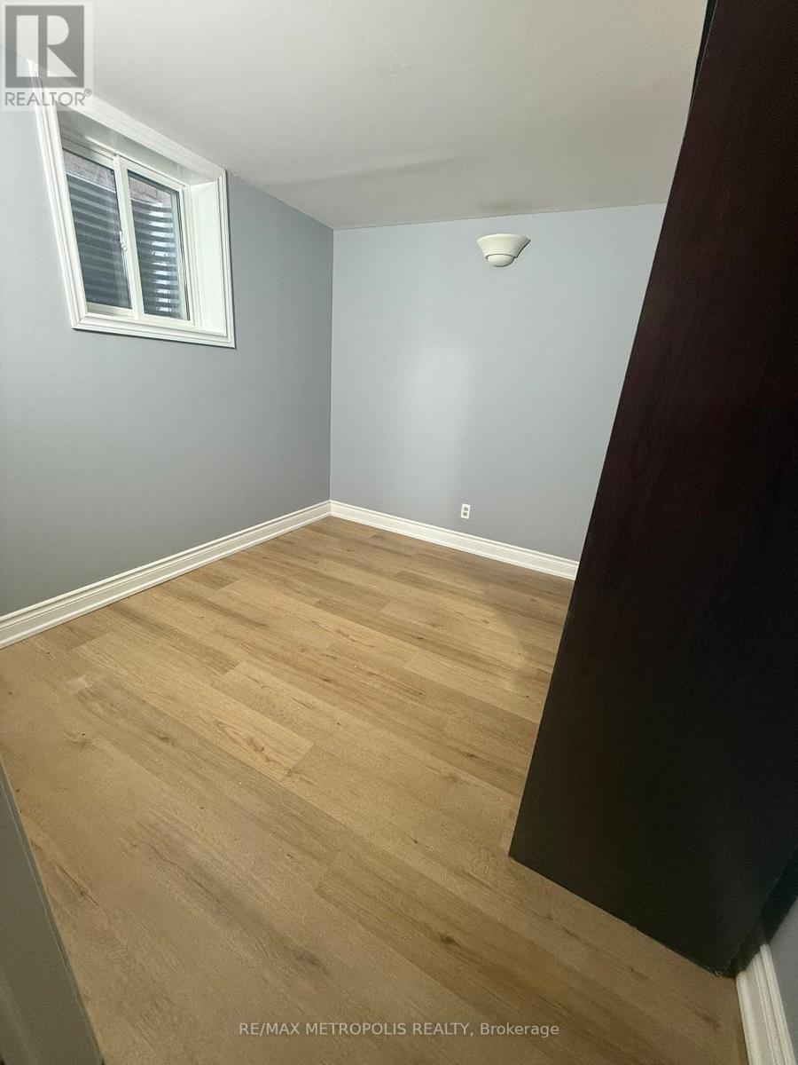 A room with wooden flooring and a window with blinds.
