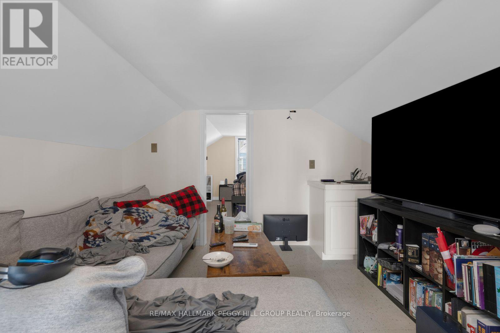 A living room with a grey couch and a black television.