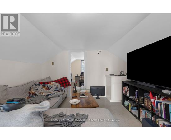 A living room with a grey couch and a black television.