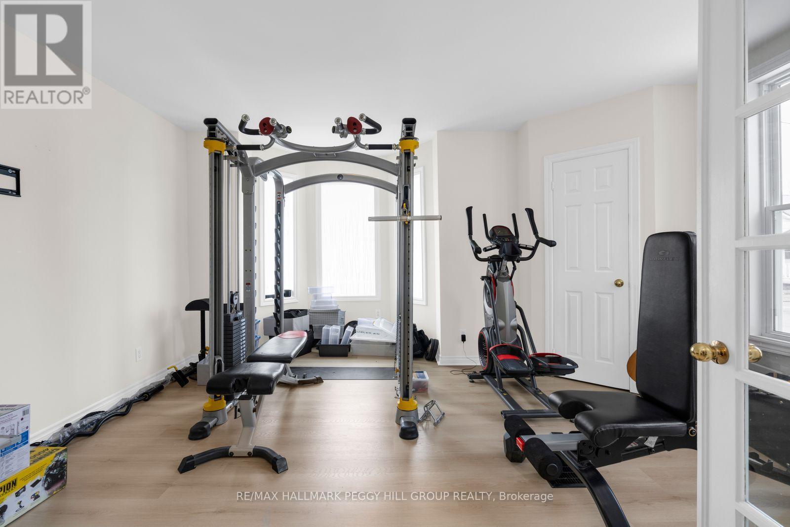 A spacious home gym with a variety of equipment including a treadmill, stationary bike, and weight machines.
