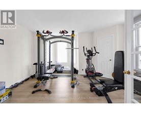 A spacious home gym with a variety of equipment including a treadmill, stationary bike, and weight machines.