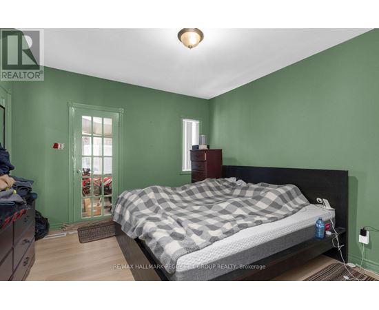 A bedroom with a bed, nightstand, and window.