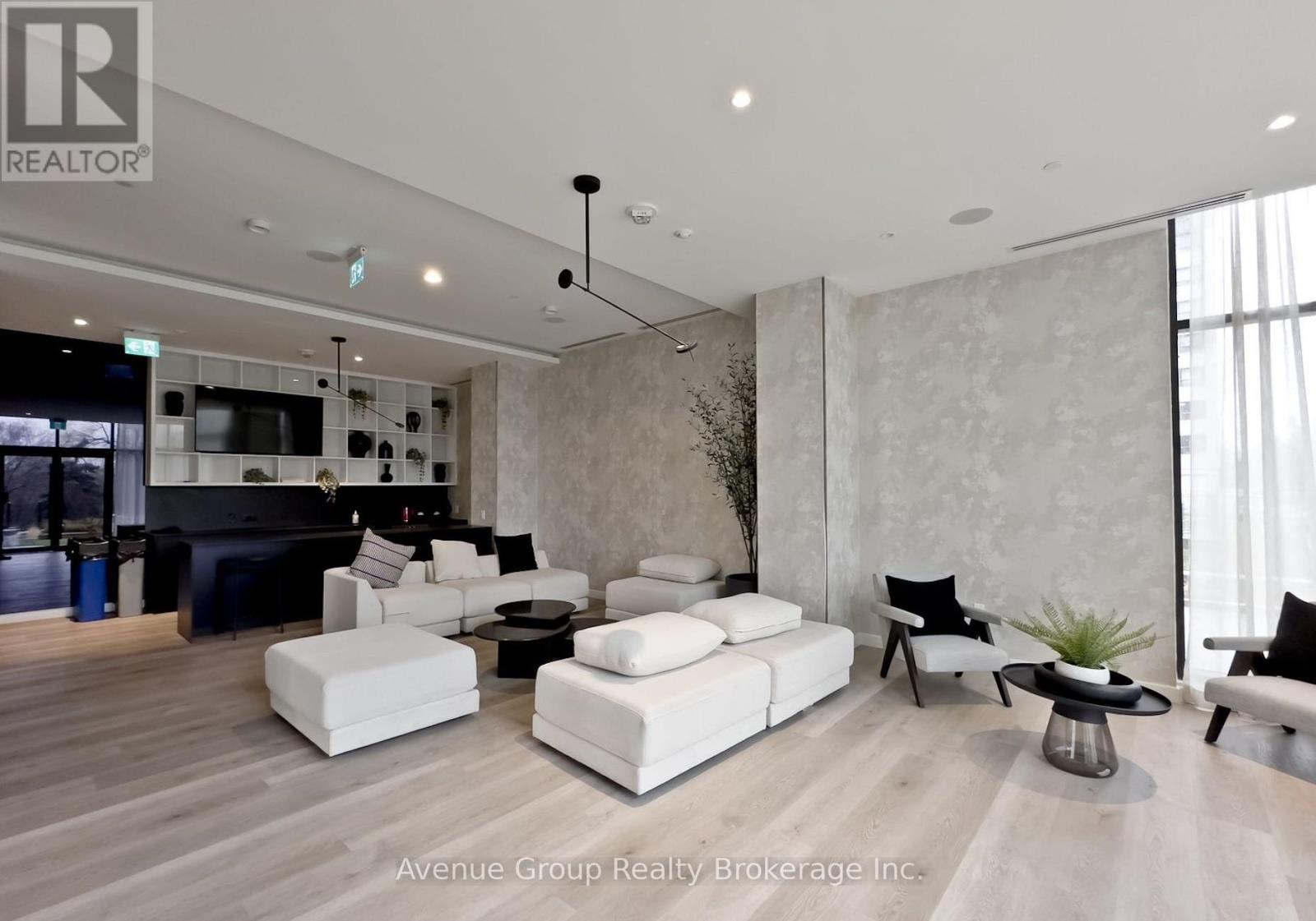 A living room with a black sofa and white couches.