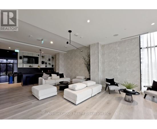 A living room with a black sofa and white couches.