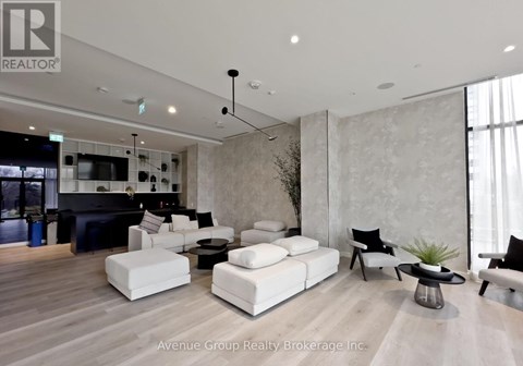 A living room with a black sofa and white couches.
