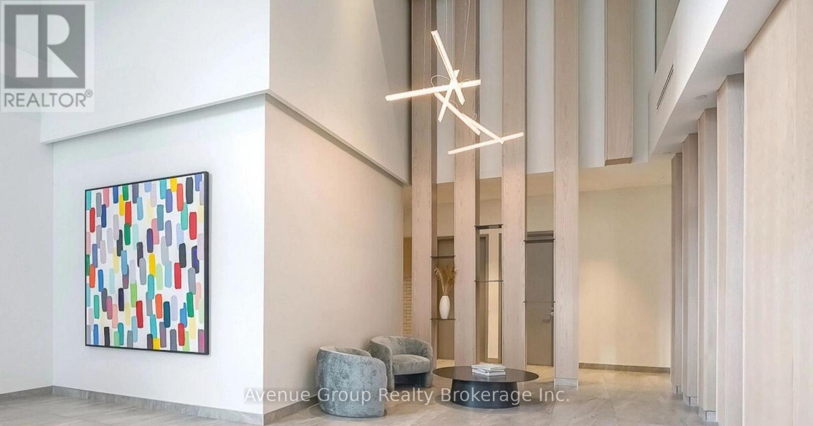 A large painting with many different colors is on the wall in a room.
