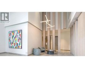 A large painting with many different colors is on the wall in a room.