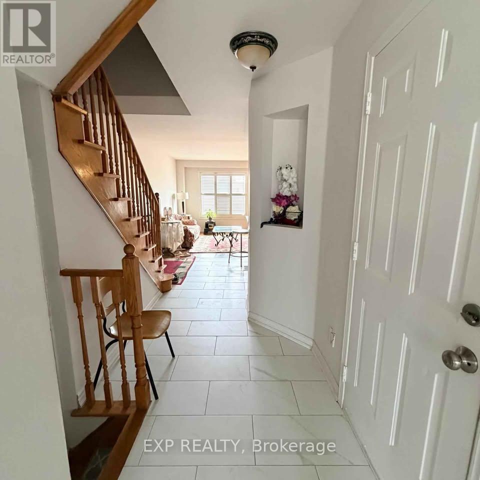 A hallway with a wooden staircase and a white door.