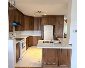 A kitchen with wooden cabinets and a white fridge.