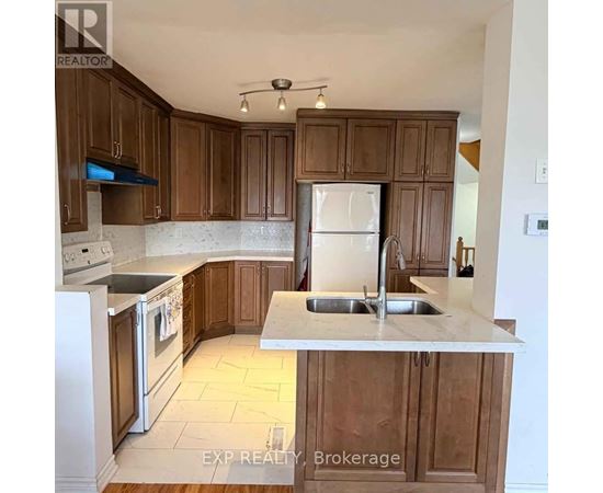 A kitchen with wooden cabinets and a white fridge.