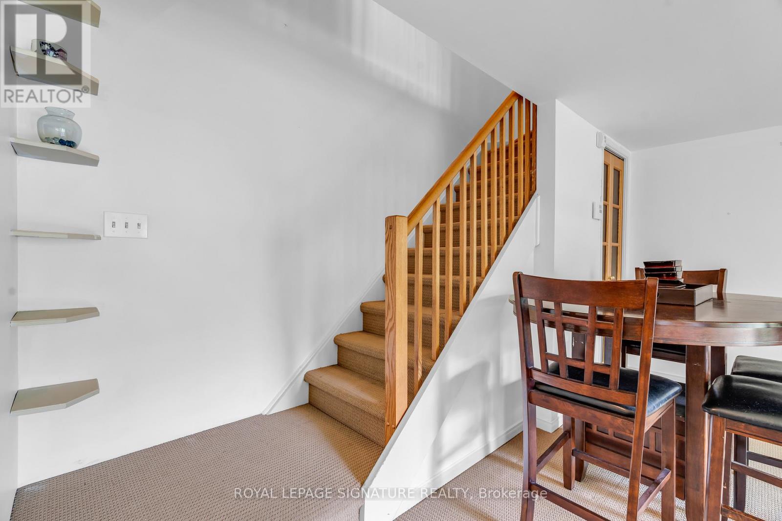 A dining room with a wooden table and chairs.
