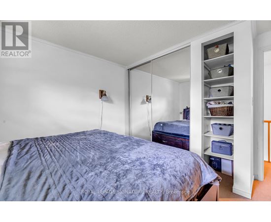 A bedroom with a bed and a closet with shelves.