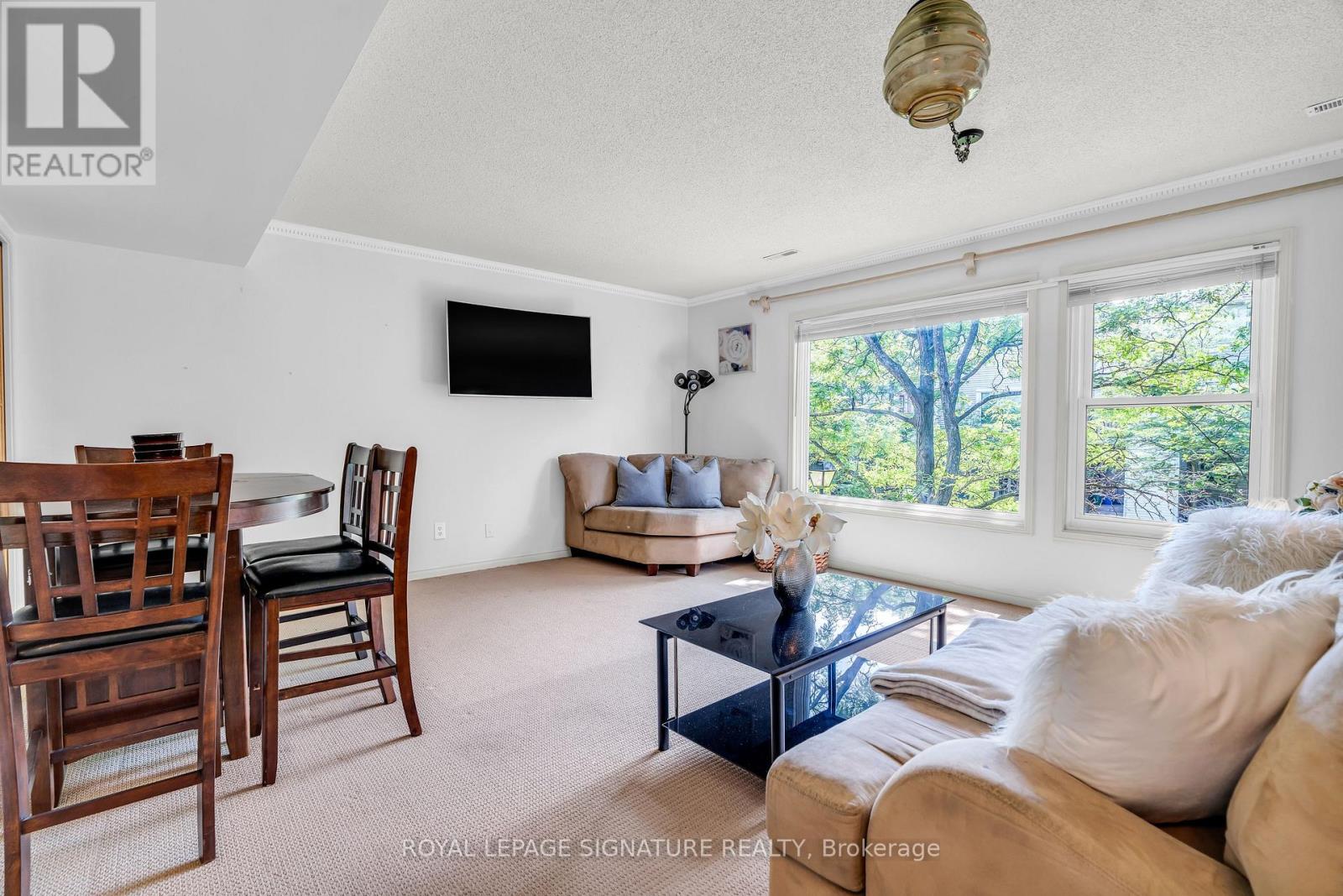 A living room with a couch, chairs, and a television.
