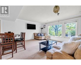A living room with a couch, chairs, and a television.