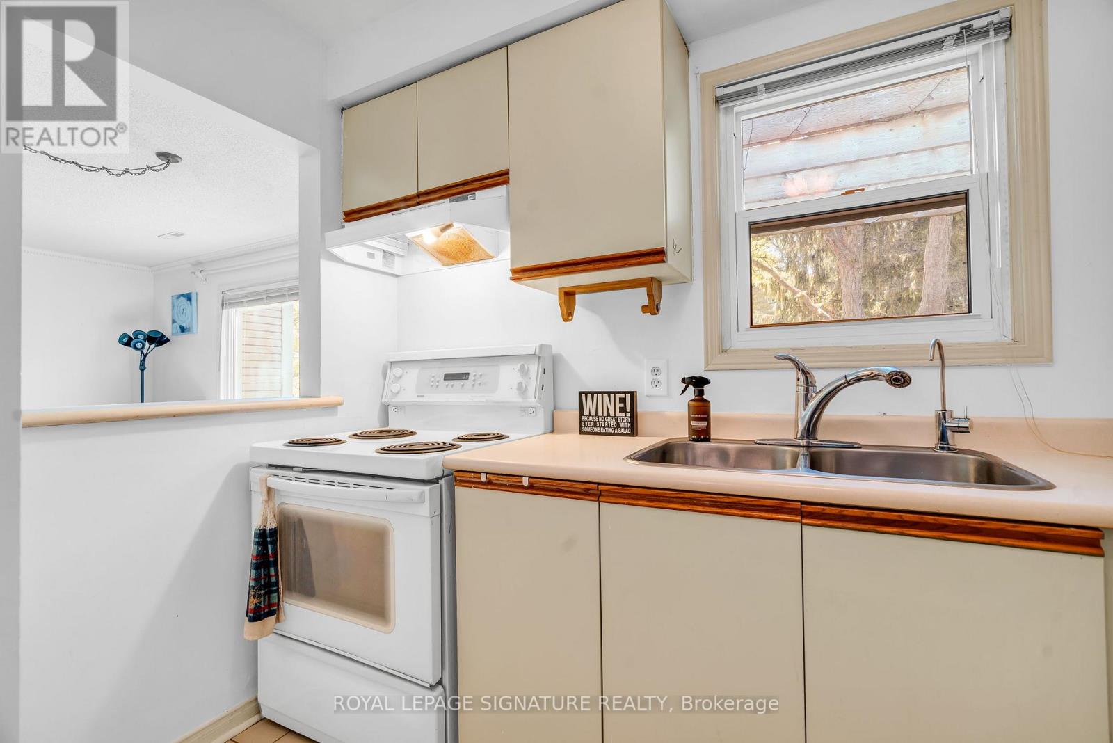 A kitchen with a white oven and beige cabinets.