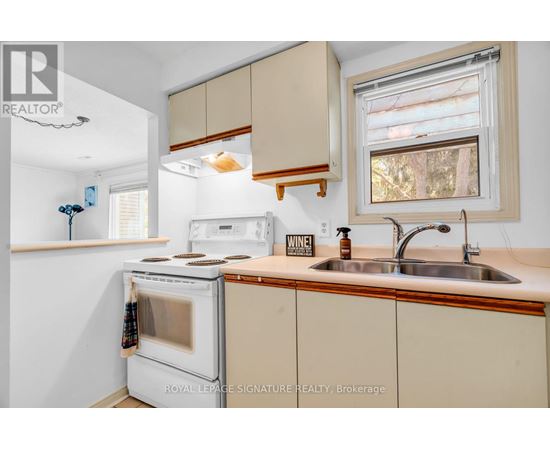 A kitchen with a white oven and beige cabinets.