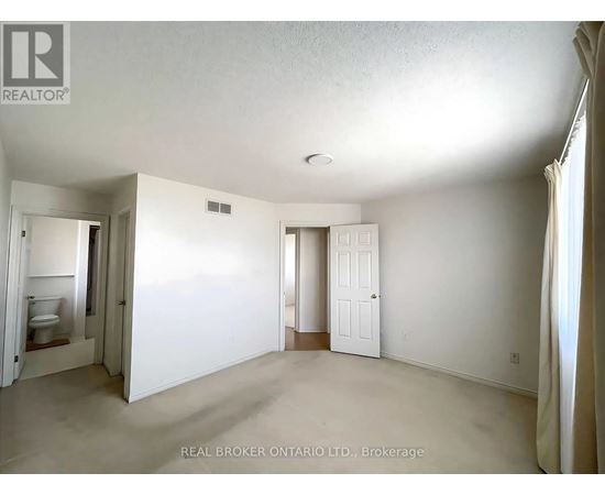 A white bedroom with a door and a window.