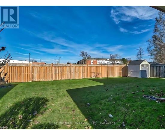 A backyard with a wooden fence and a small building.